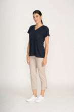 Load image into Gallery viewer, Woman wearing a navy blue top and beige pants on a white background